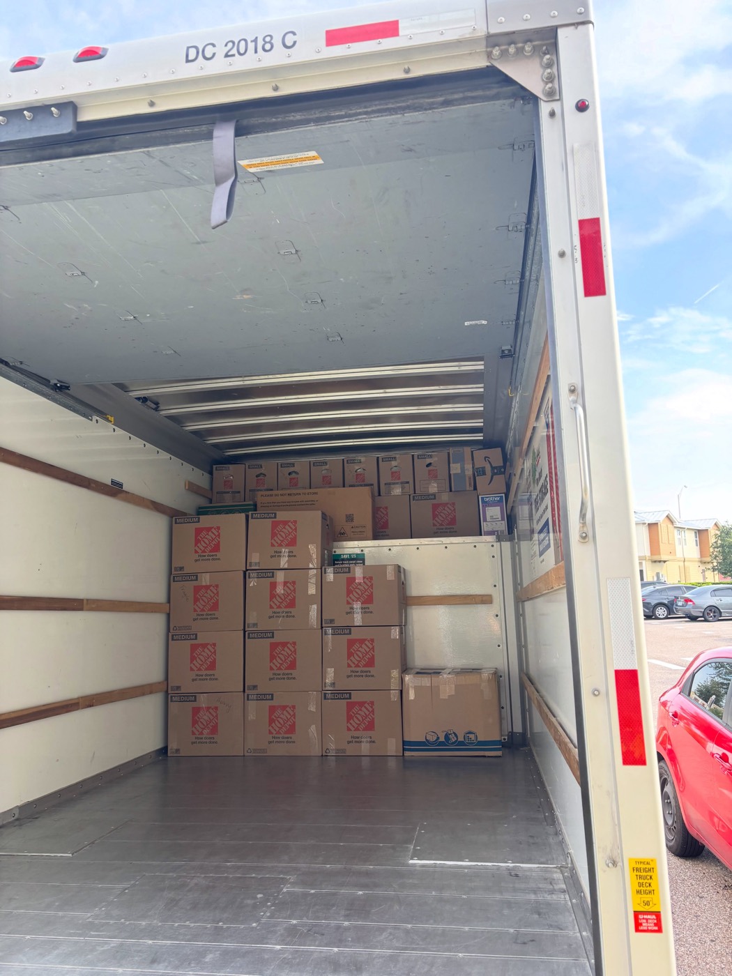 Camión de mudanza cargado del piso al techo con cajas y muebles bien acomodados